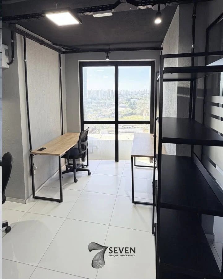 Sala privativa com duas mesas, estante e janela com vista da cidade